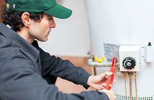 Service tech fixing hot water heater